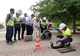 Un operario limpia uno de los imbornales en una plaza del barrio de Zaidín Campus.