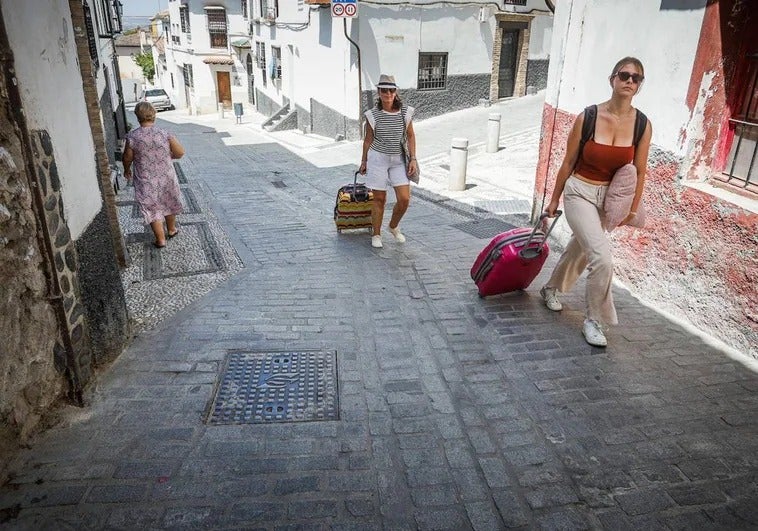 Turistas arrastran sus maletas por una calle albaicinera.
