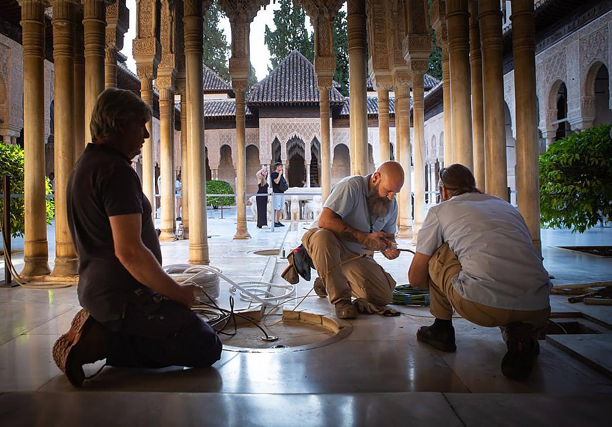 Operarios trabajando ayer por la mañana en la reparación de la fuga en el Patio de los Leones de la Alhambra.