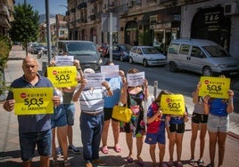 Vecinos de la calle Jardines de Armilla posan con pancartas reivindicativas.