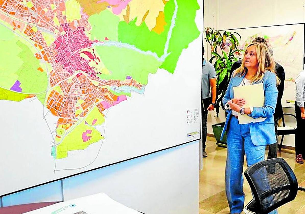 La alcaldesa revisa un mapa de la ciudad.