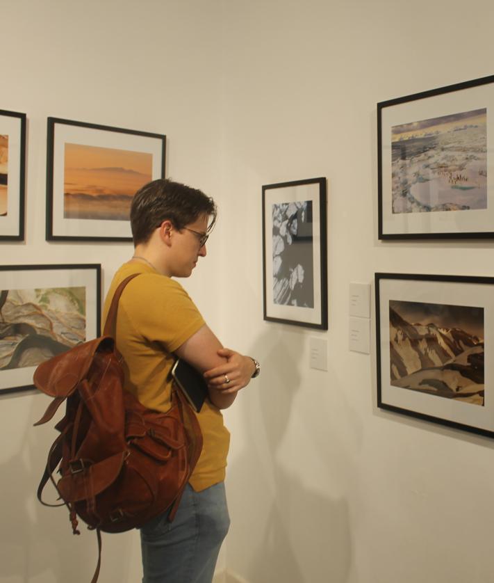 Imagen secundaria 2 - Arriba 'El Creata' con su obra 'We water again' y abajo el público contemplando las fotografías