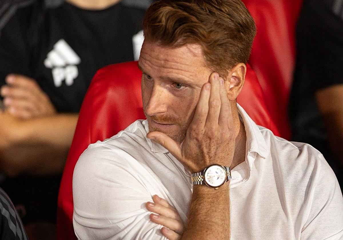 Guille Abascal, con gesto preocupado en el banquillo del Granada.