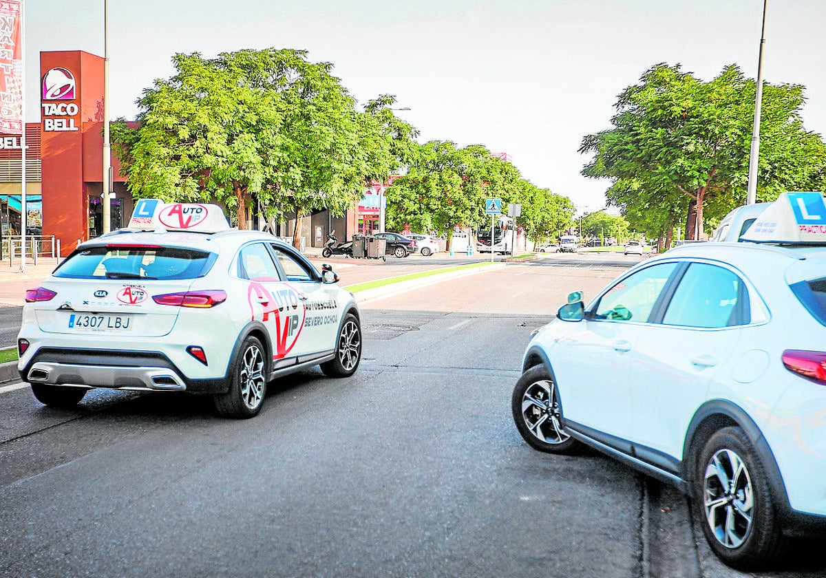 Dos coches de autoescuela, en un examen para obtener el carnet de conducir en la capital.