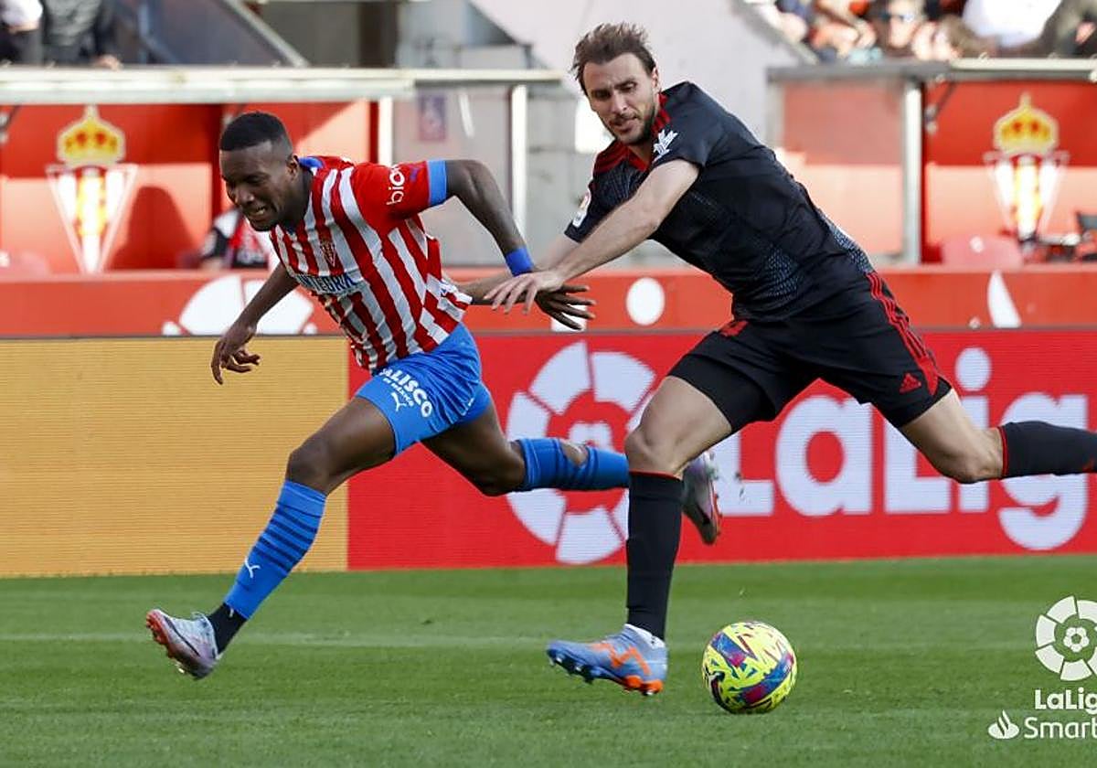 Ignasi Miquel, de negro, pugna por el balón ante un jugador del Sporting.