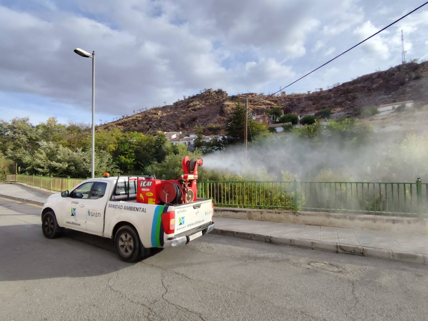 Uno de los vehículos 'pick up' de Athisa Medio Ambiente fumigando este sábado en Pinos Puente.