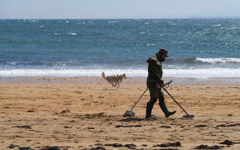 Imagen de archivo de un hombre haciendo uso de un detector de metales en una playa.