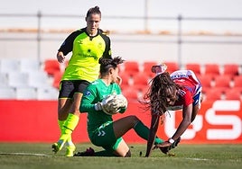 La rojiblanca Edna tropieza ante la salida de la guardameta del Real Betis.