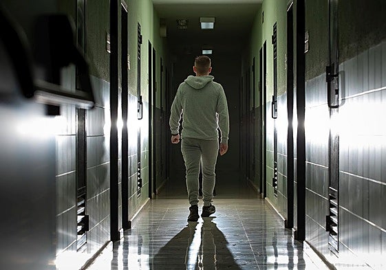 Alejandro, interno del centro de inserción social de Granada, camina por el pasillo donde están las celdas.