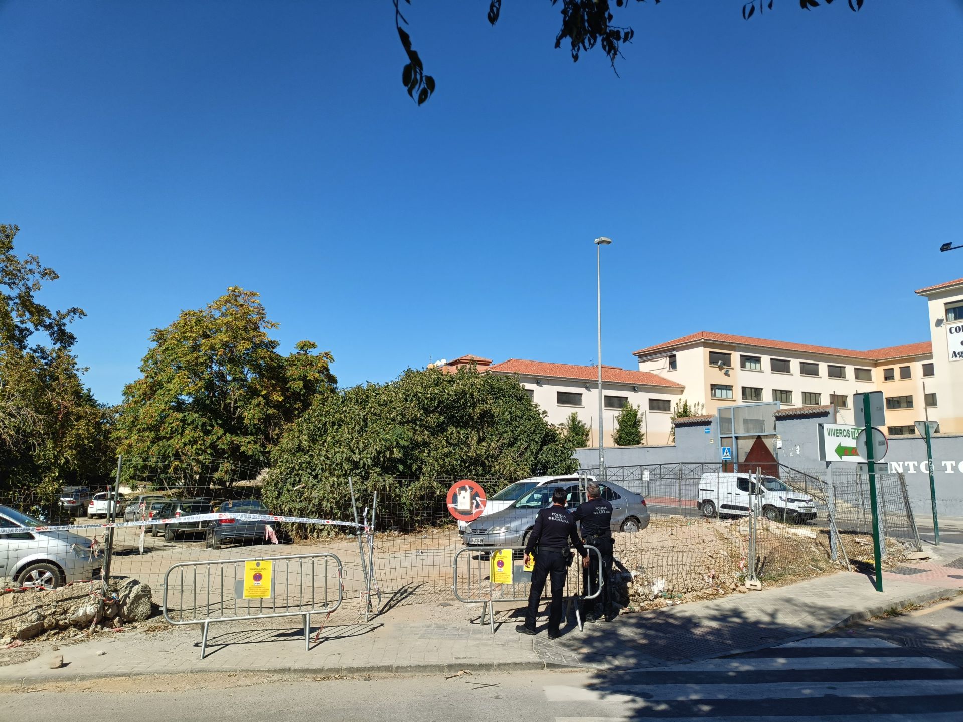 Dos agentes de la Policía Local comprueban el estado de la verja que da acceso al solar donde se ha proyectado una gran zona verde.