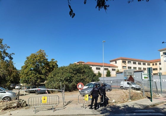 Dos agentes de la Policía Local comprueban el estado de la verja que da acceso al solar donde se ha proyectado una gran zona verde.