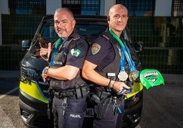 Juanjo Rojas y Mariano Ruiz, agentes de la Policía Local de Granada, muestran sus medallas y los 'útiles' de sus respectivos deportes.