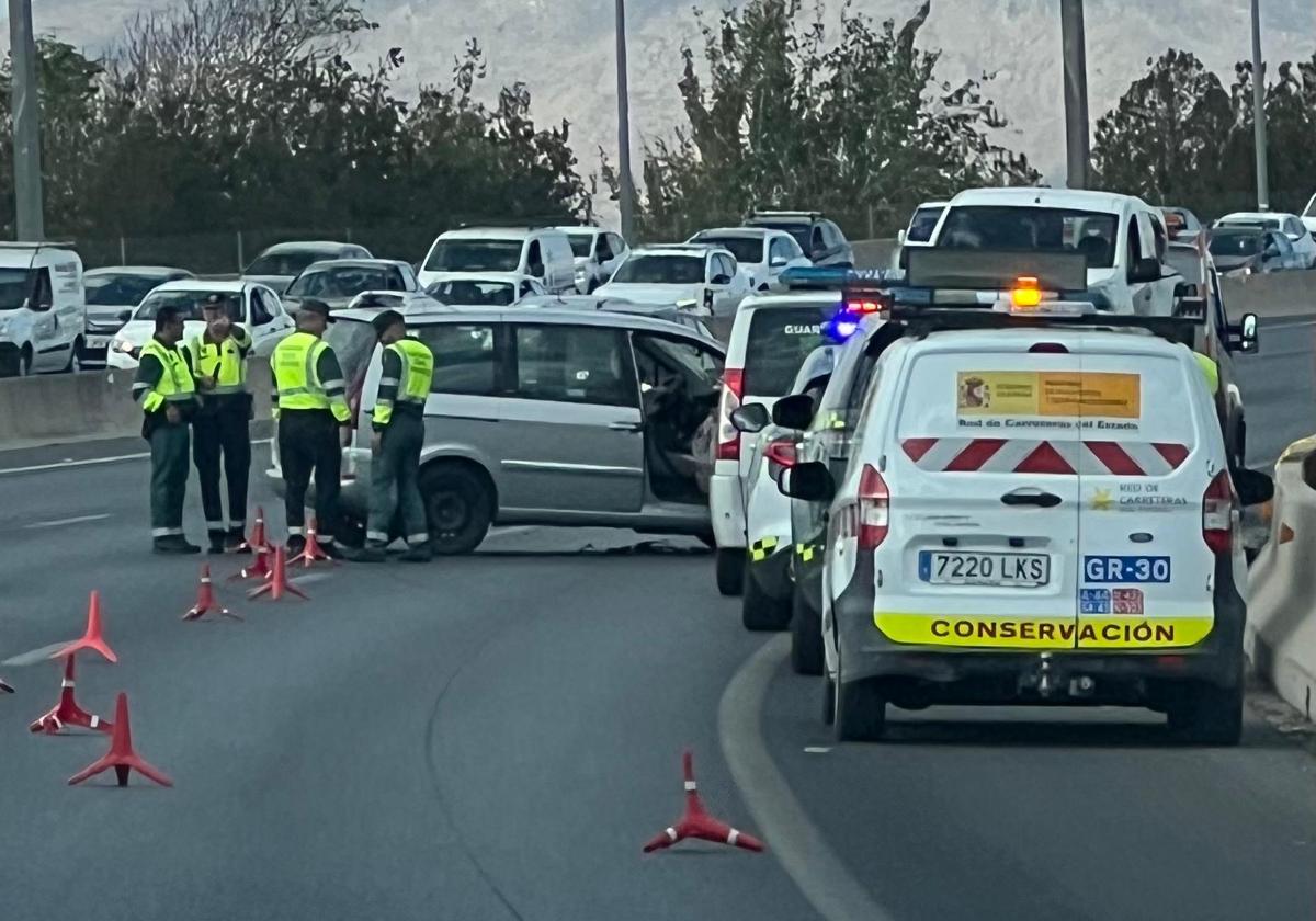 Uno de los coches accidentados, junto a la Guardia Civil.