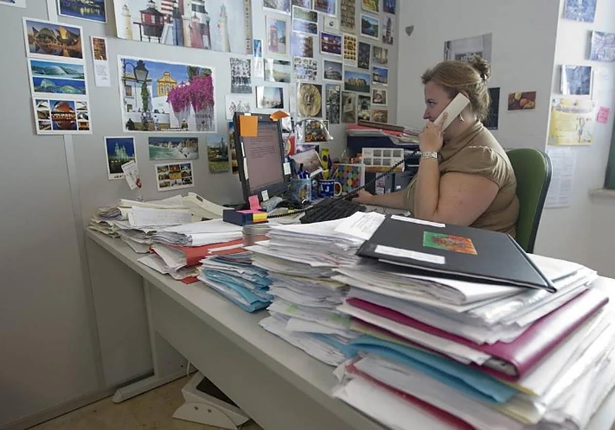 Una trabajadora municipal atiende un servicio en su despacho.