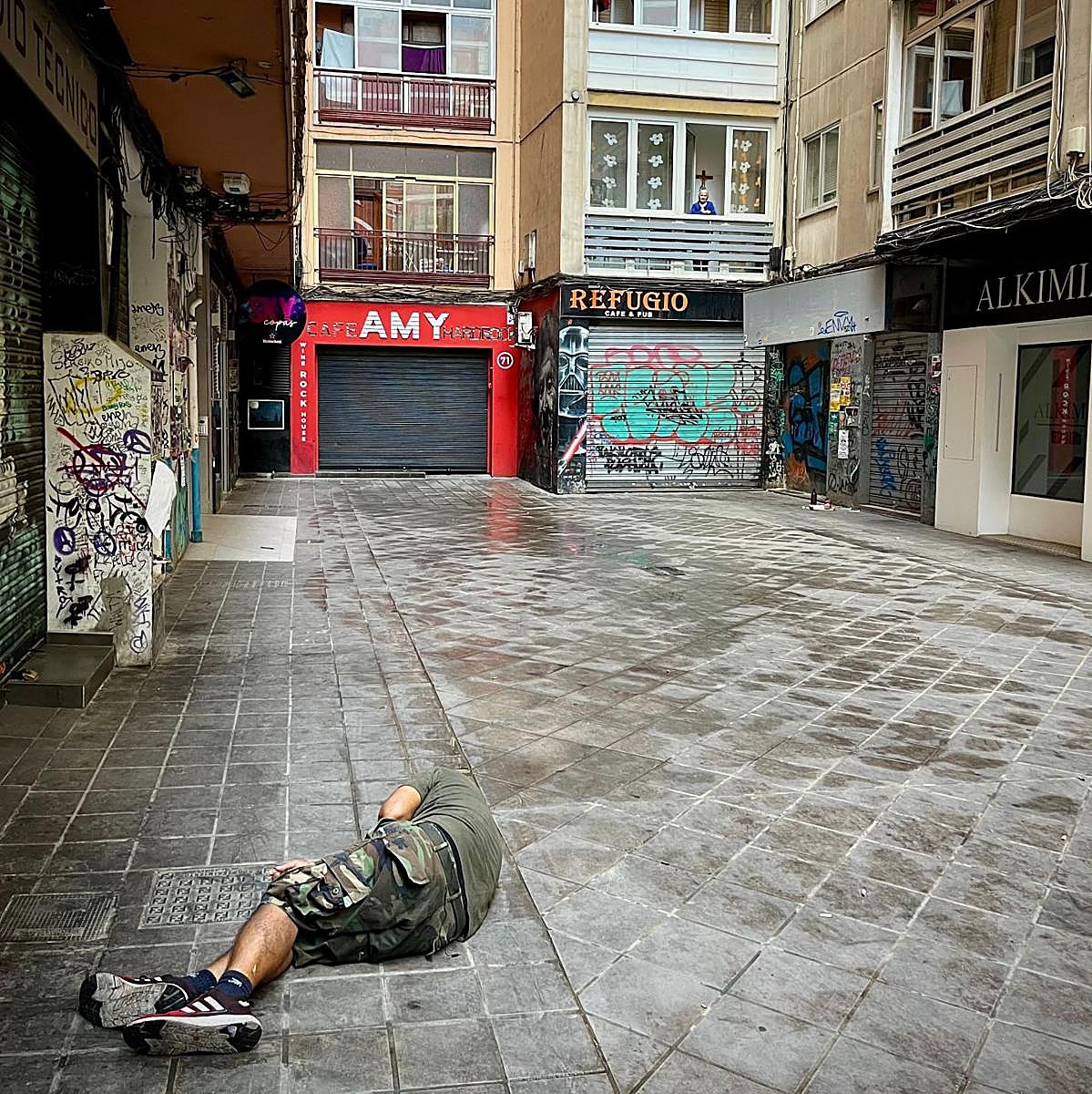 Un hombre duerme en la calle mientras Ángeles observa.