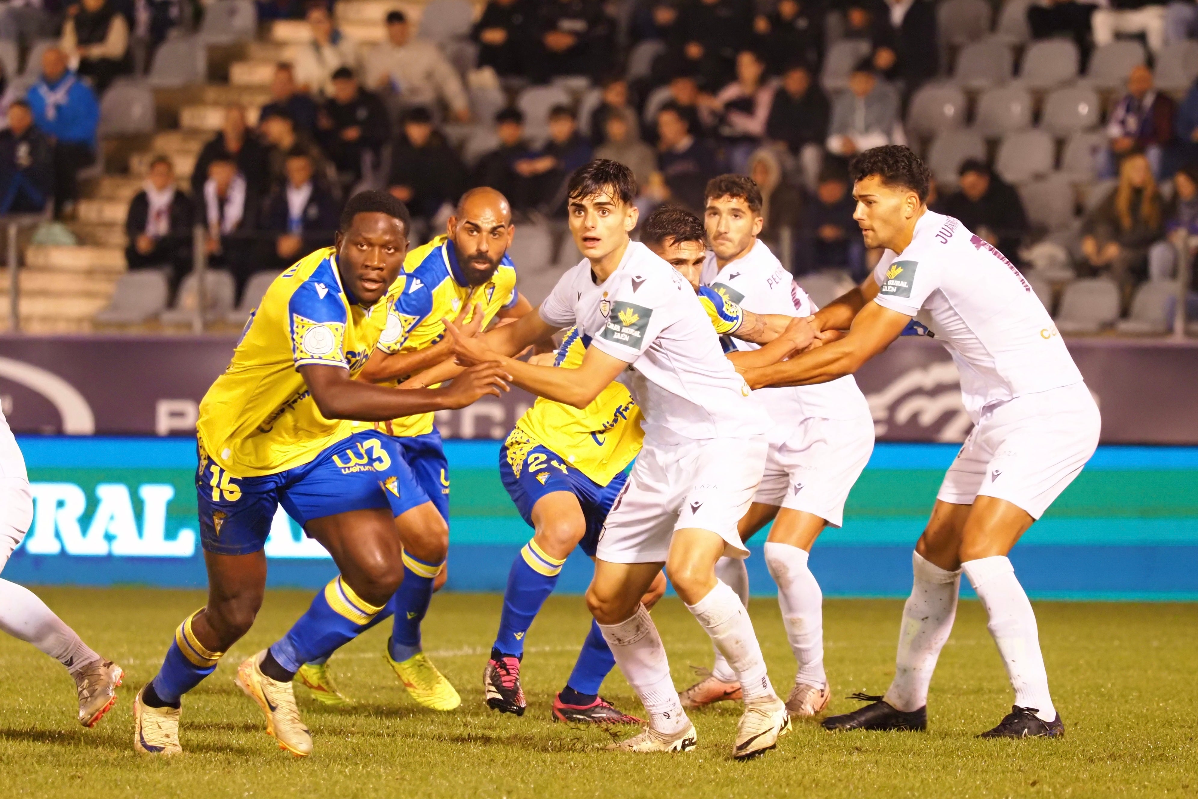 Jugadores del Cádiz y de Real Jaén pendientes de la llegada de un balón.
