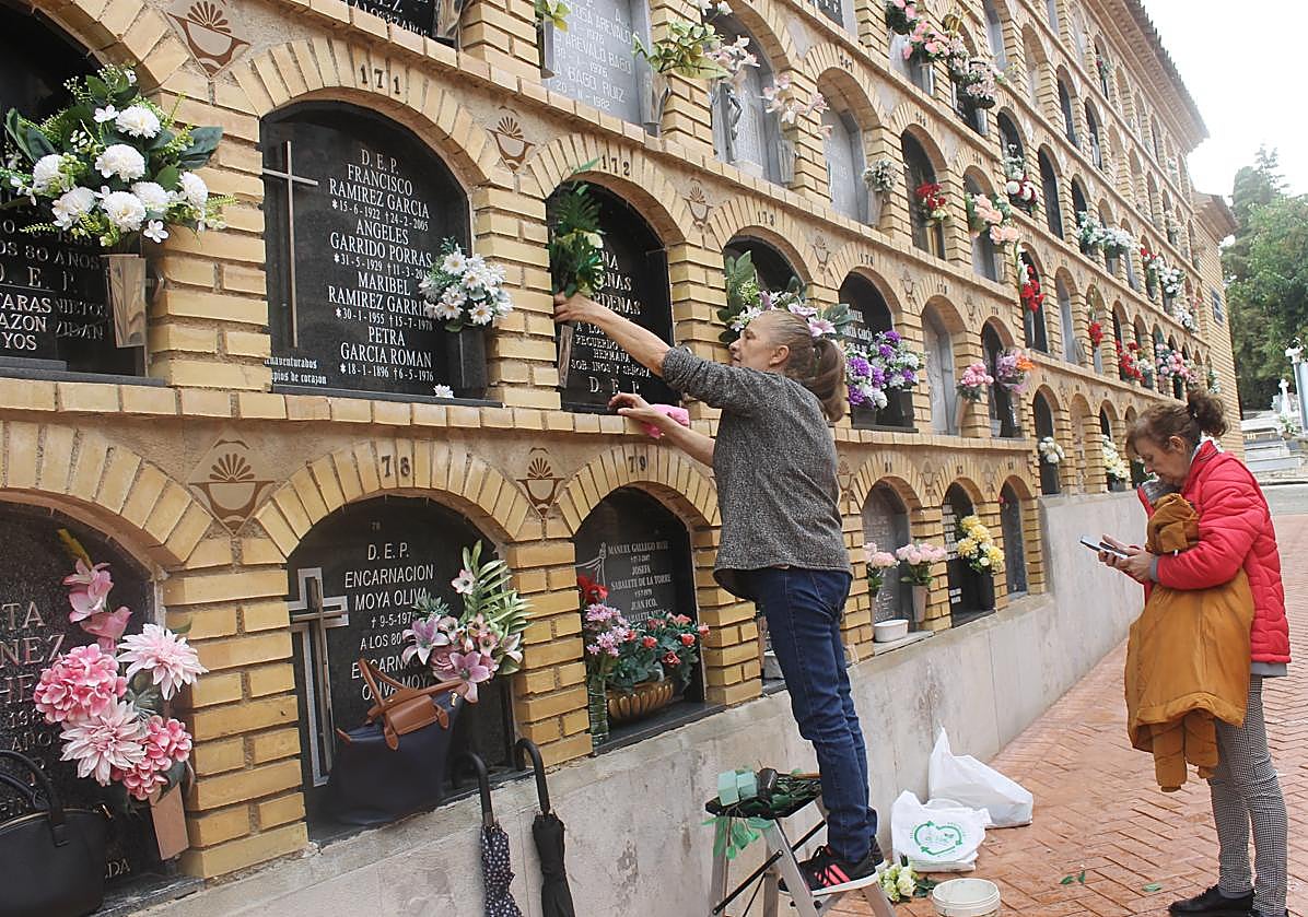 Imagen principal - Varias familias colocando flores y un florista preparando un ramo