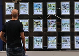 Un hombre observa los anuncios del escaparate de una agencia inmobiliaria.