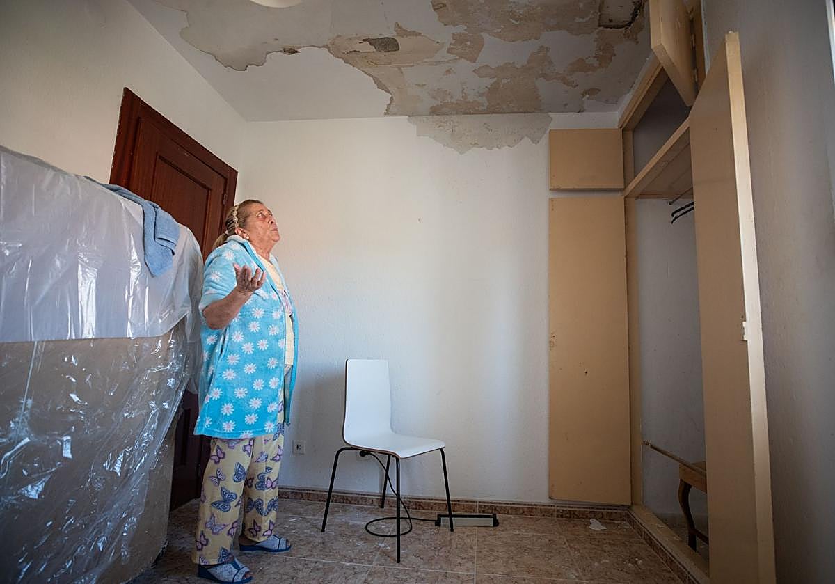 Josefa observa el techo de su casa diez días después de las lluvias que provocaron la filtración de agua.