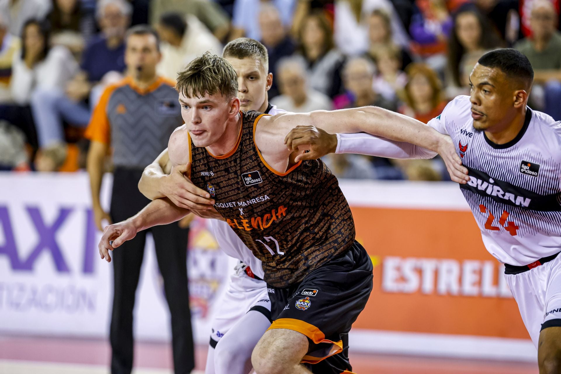 Valtonen y Wiley sujetan al letón Steinbergs durante el partido de esta noche en el Congost.