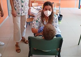 Un niño recibe una vacuna en un centro educativo.