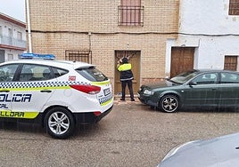 Un agente precinta la puerta del domicilio.