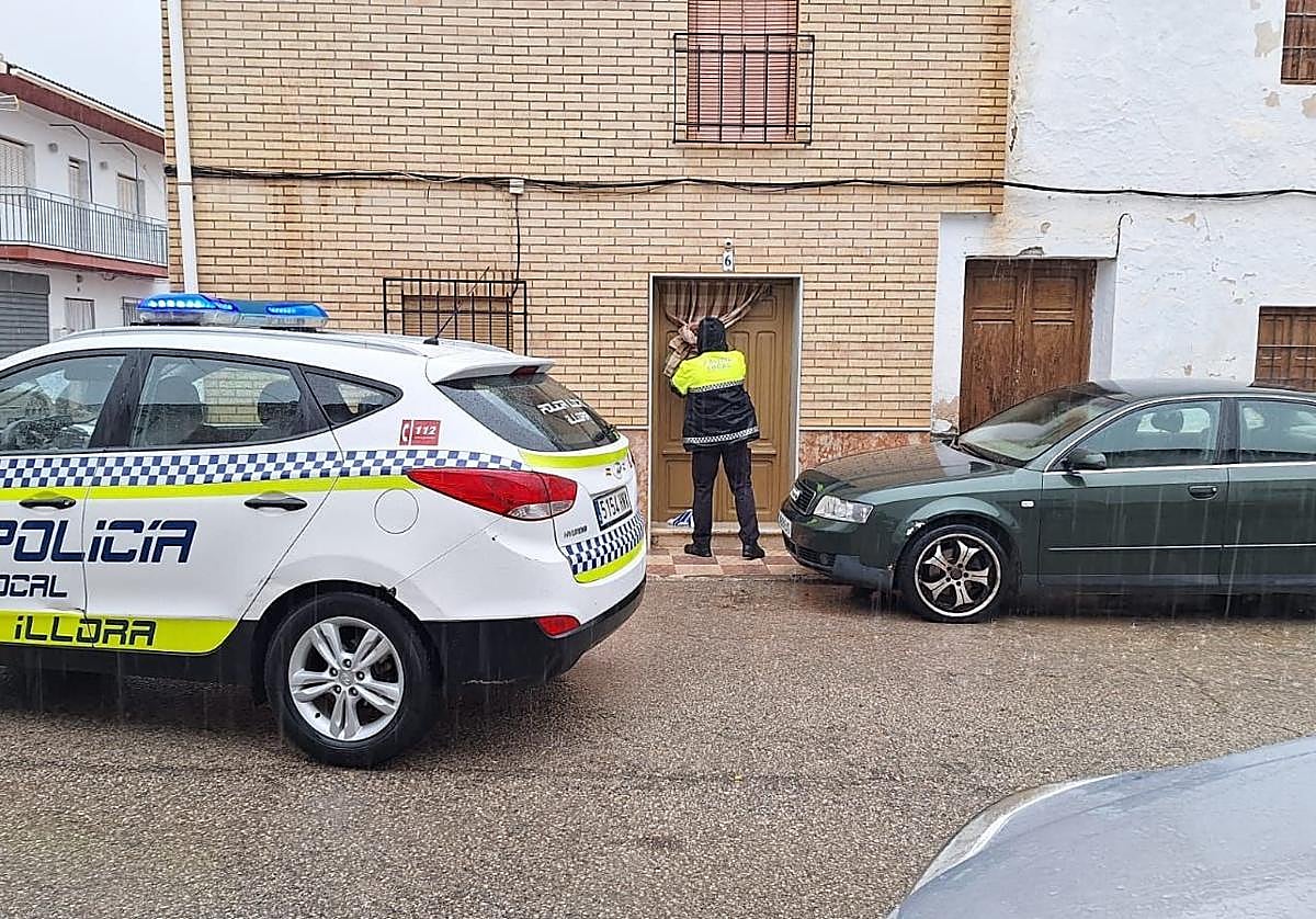 Un agente precinta la puerta del domicilio.