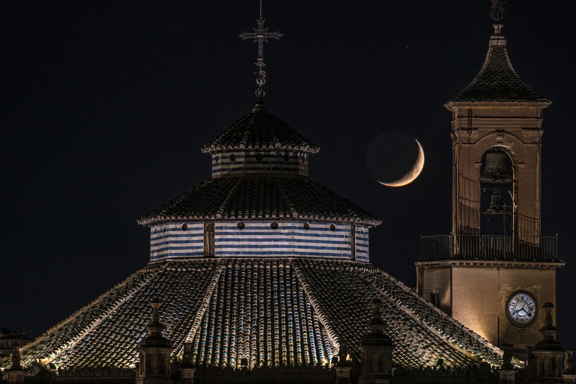 Espectacular instantánea de la Luna en fase creciente entre la cúpula y la torre del reloj de la Catedral de Granada