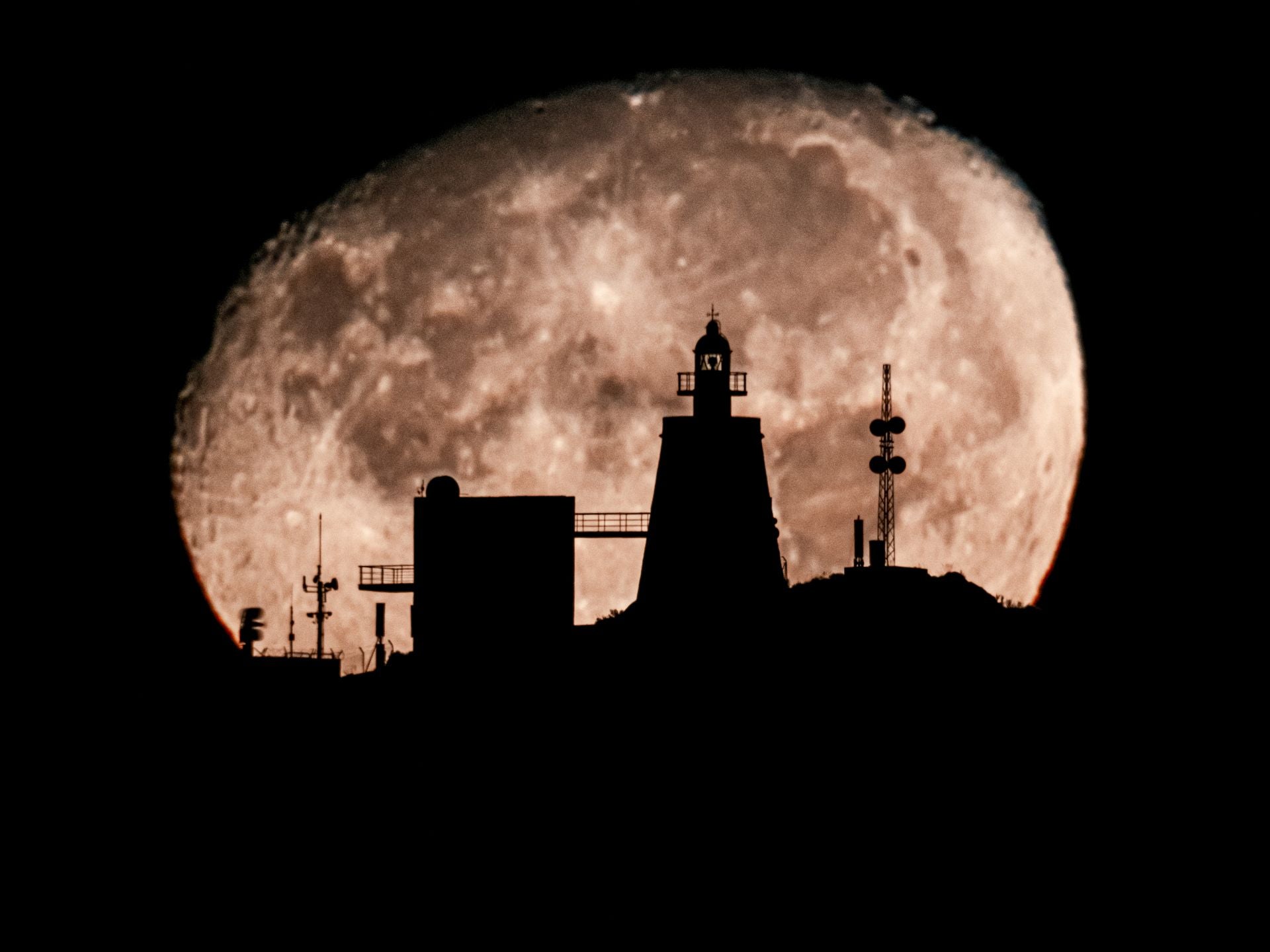 Fotografía del Faro de la Punta del Melonar y la Torre de la Estancia, en Castell de Ferro, tomada desde el Castillo de Baños, a cinco kilómetros de distancia. Se observa toda la orografía lunar. 