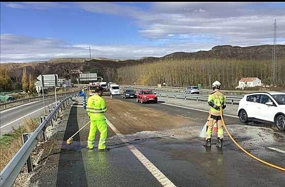 El personal de mantenimiento y los Bomberos de la Diputación, durante las tareas de limpieza del asfalto.