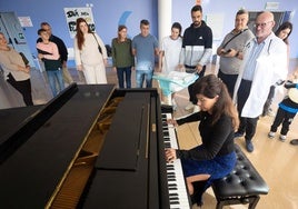 Marian Munilla, en el piano, y el doctor Diego Fernández, con pacientes de la planta de Pediatría.