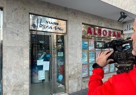 Un cámara de televisión graba la fachada de la oficina de 'Viajes Alborán' tras conocerse el cierre temporal.