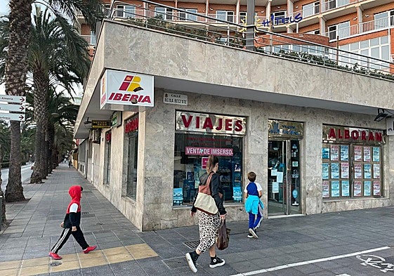 Una familia observa el local cerrado y vacío de la agencia.