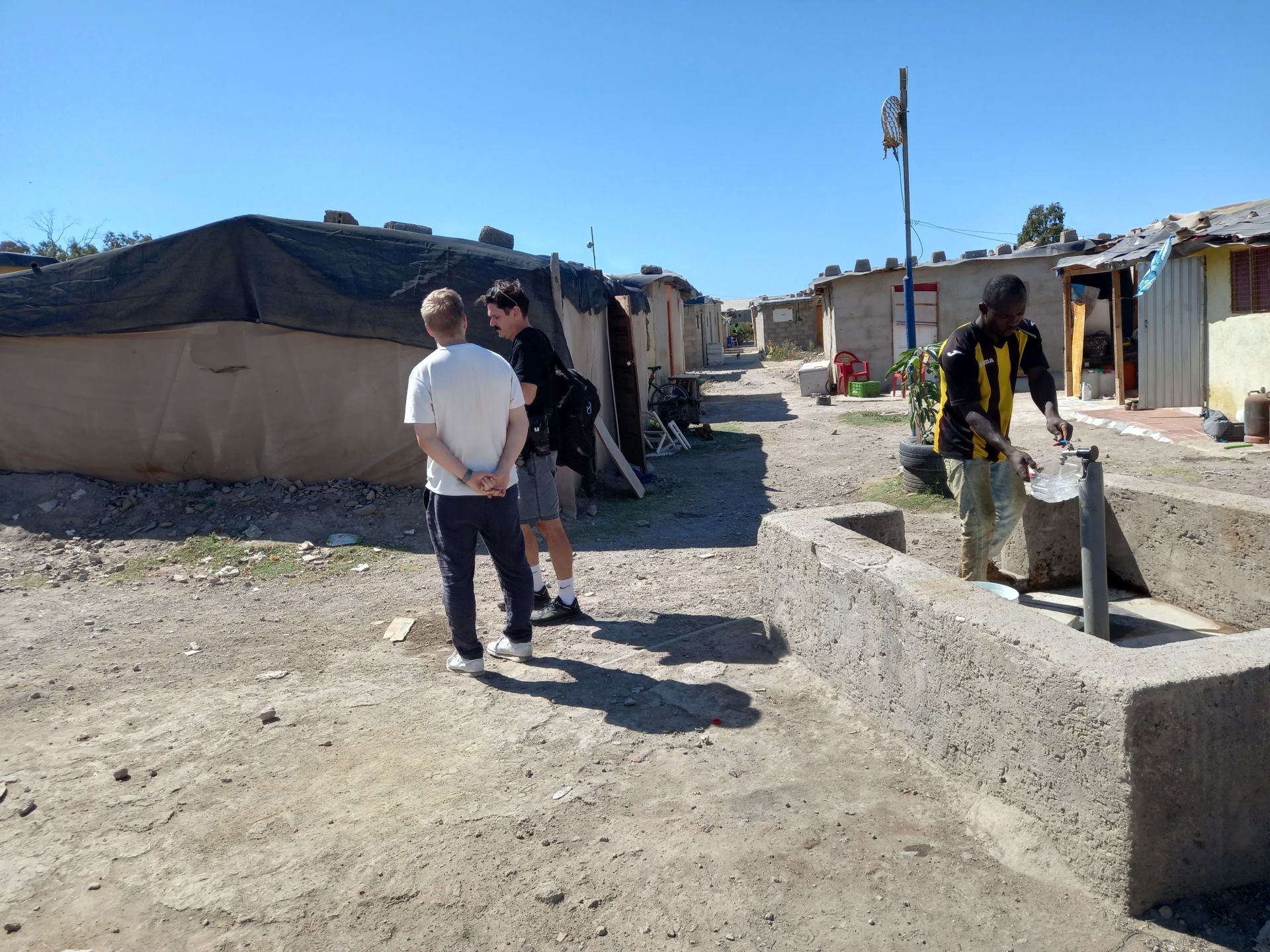 Un residente del poblado de Atochares llena un recipiente con agua en la fuente común.