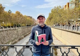 Alejandro Pedregosa posa con su último libro, 'Comadrejas', en el puente de San Antón, sobre el Genil.