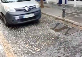 Un vehículo al paso de las arquetas de la calle Santiago.