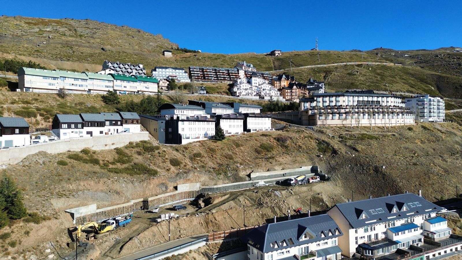 Imagen principal - El muro de contención ya construido en la ladera donde se levantará el complejo hotelero y recreación del edificio y el interior de uno de los apartamentos.