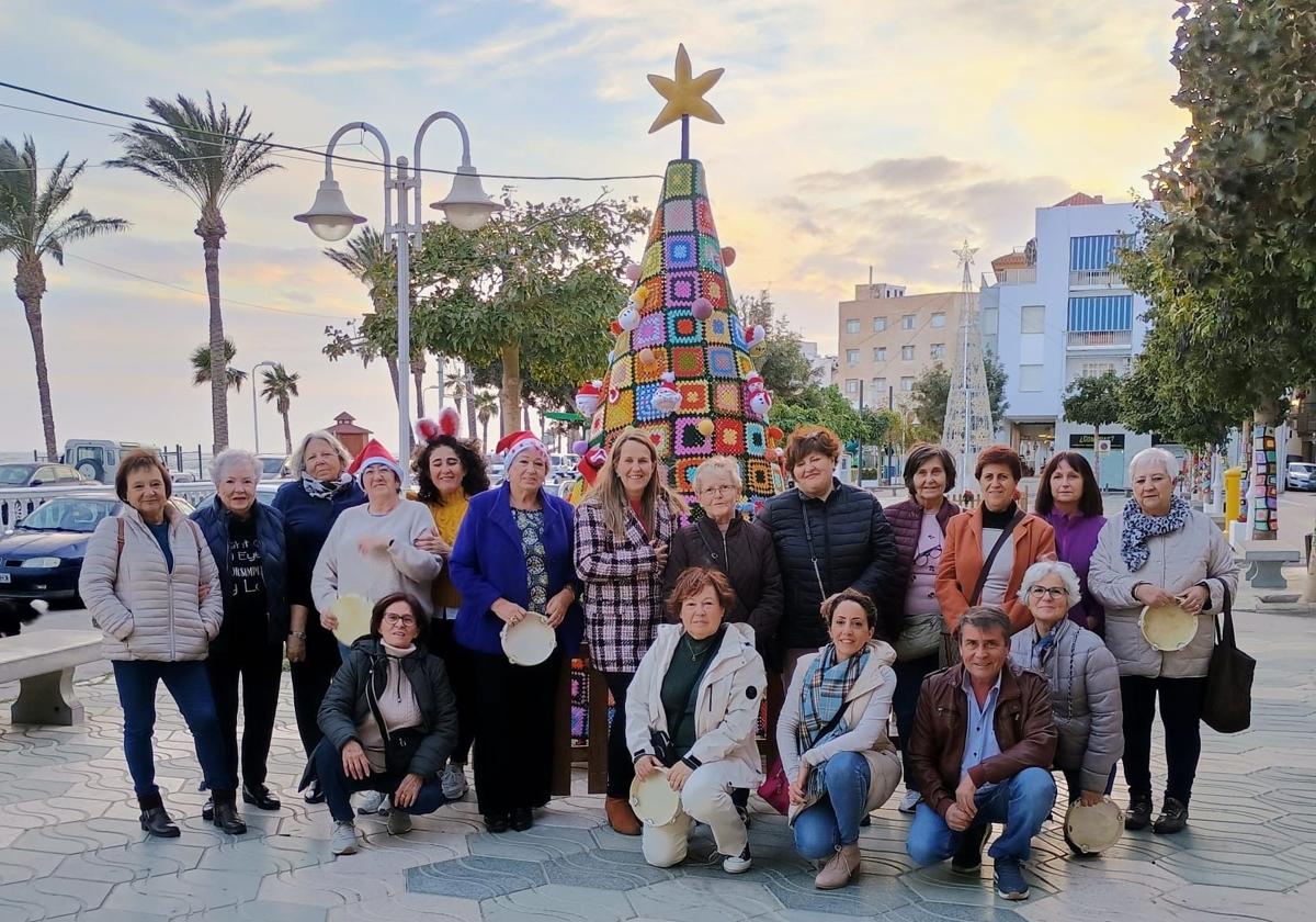 Las mujeres de la asociación posan con el árbol de Navidad.