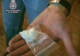 Un agente de la Policía Nacional muestra un dosis de cocaína intervenida a una banda de narcos que la vendían a domicilio.