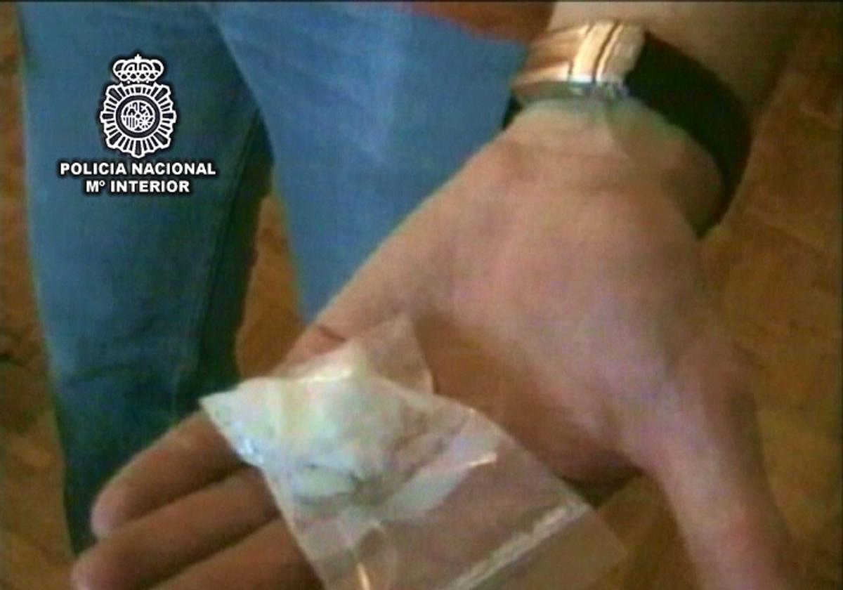 Un agente de la Policía Nacional muestra un dosis de cocaína intervenida a una banda de narcos que la vendían a domicilio.