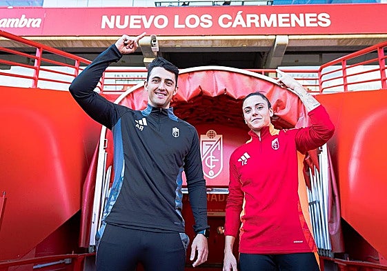 Arturo Ruiz y Alba Pérez señalan el cartel de Los Cármenes después del último entrenamiento del equipo previo al partido.