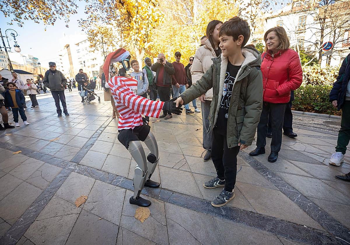 Imagen principal - Gabril y María Azucena saludan al robot, en la Fuente de las Batallas. 