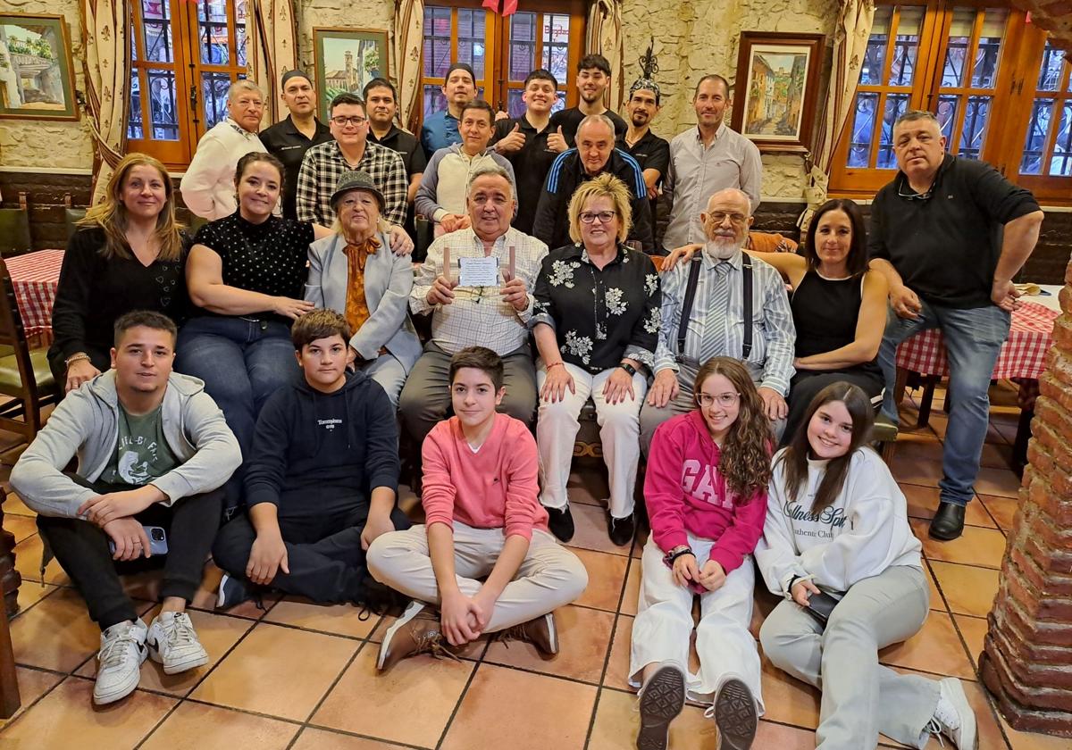 Ramírez muestra la placa recibida junto a su mujer, la familia propietaria y los compañeros de trabajo.