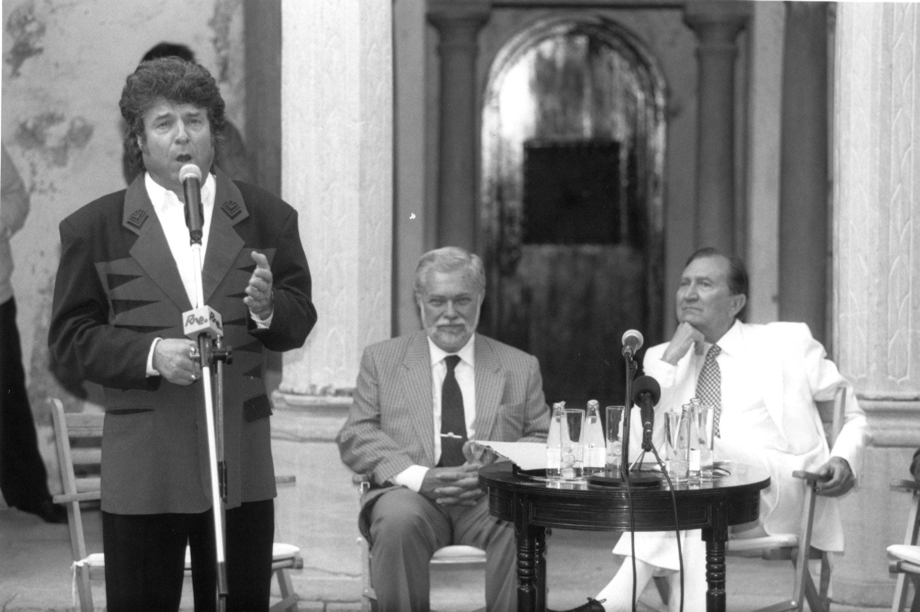 El cantaor Enrique Morente cantando tras recibir la medalla de oro de la Fundación Rodríguez Acosta. Junto a él, el alcalde Gabriel Díaz Berbel y el académico granadino Miguel Rodríguez-Acosta. Año 1995