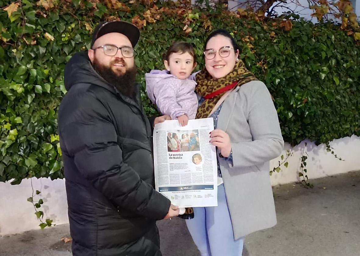 Nabila y sus padres con la página de IDEAL en la que se publicó su caso.