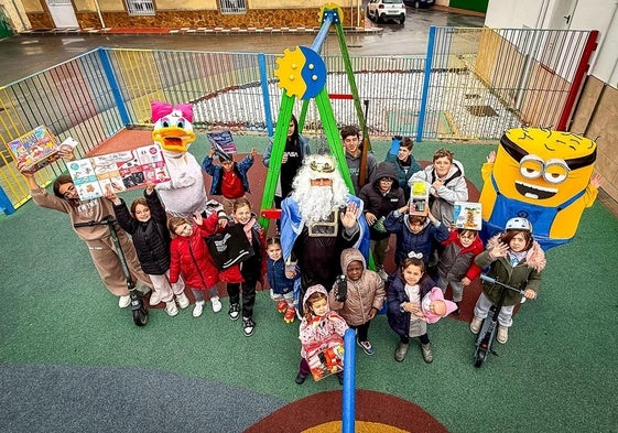 El Rey Mago Melchor con sus pajes vestidos de Minion y Daisy, con los niños de Gobernador, que enseñan sus regalos.