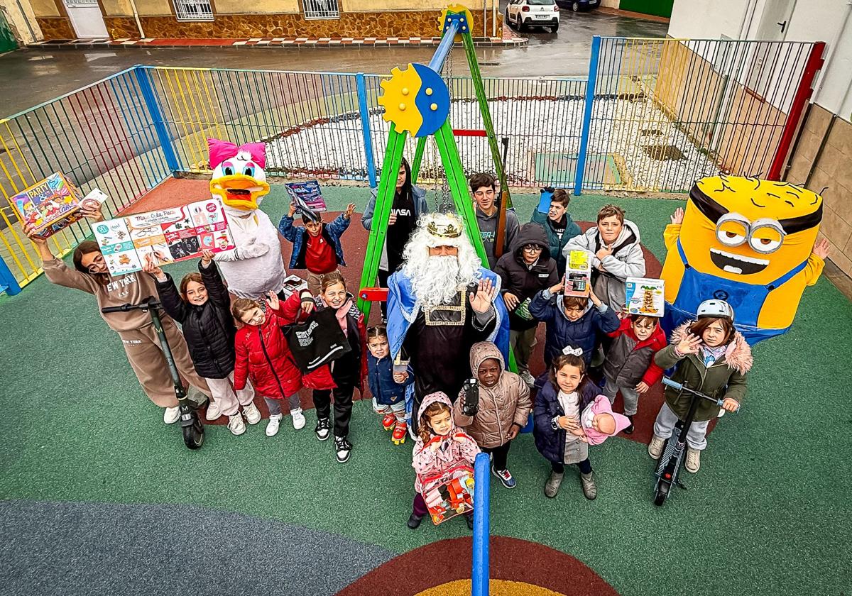 El Rey Mago Melchor con sus pajes vestidos de Minion y Daisy, con los niños de Gobernador, que enseñan sus regalos.