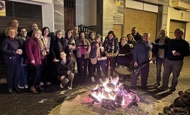 Vecinos posando junto a la hoguera con las migas