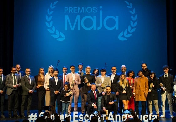 Foto de familia con autoridades y ganadores en el Teatro Isabel la Católica.