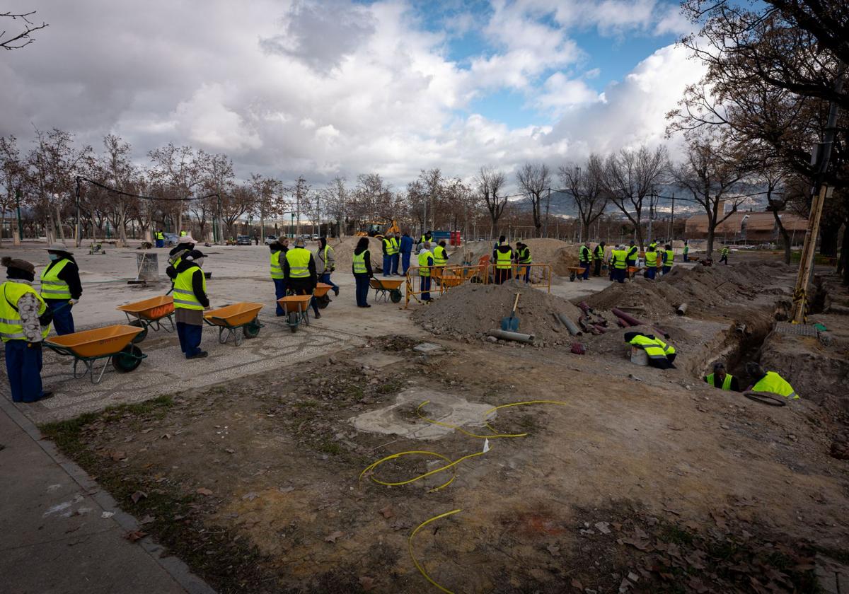 Un grupo de peones con carretillas trabaja en la ubicación de la caseta del Ayuntamiento de Granada.